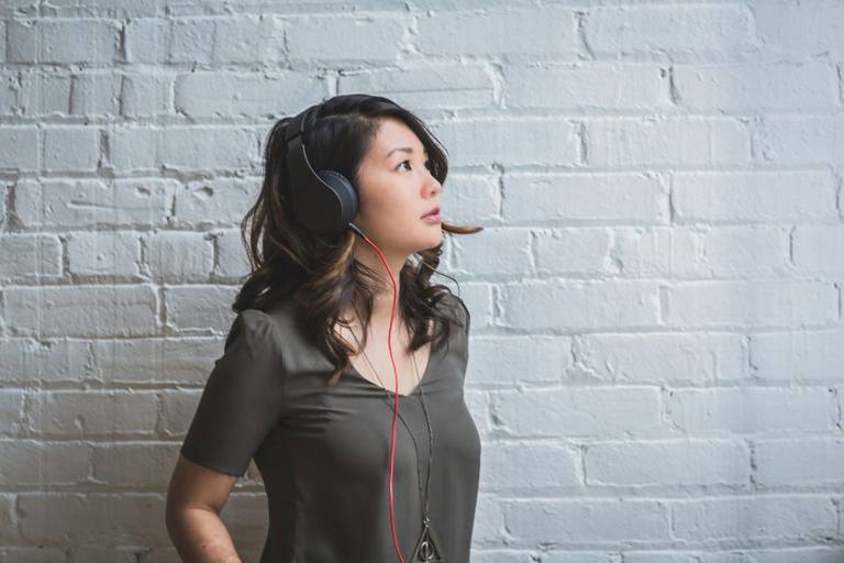 Une personne écoute un audio au casque, illustration du format dominant des contenus de biokinésie diffusés en ligne.