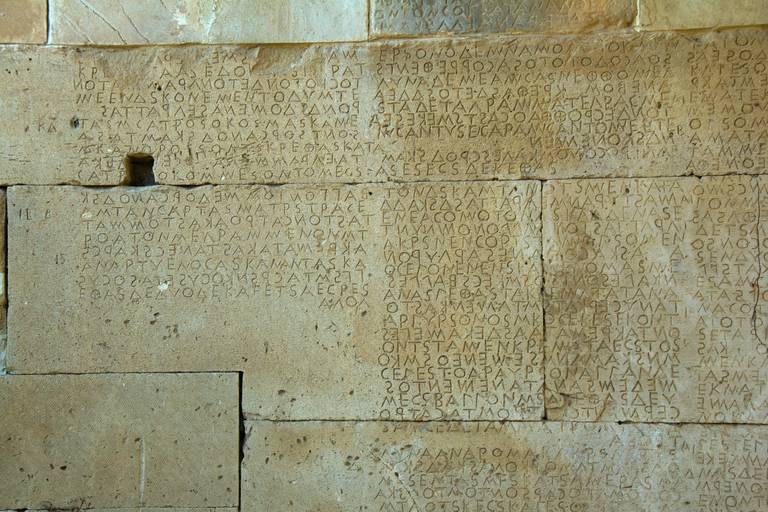 Inscription en grec ancien gravée dans les blocs de pierre du code de Gortyne, sur le site archéologique de Gortyne en Crète.