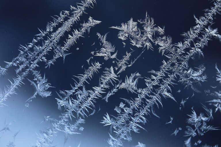 Cristaux de givre formés sur une vitre en hiver, exemple de cristallisation naturelle confondue avec un effet de cryokinésie