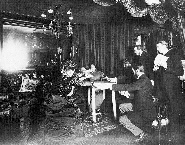 Photographie d'époque d'une séance d'Eusapia Palladino, la table soulevée du sol devant plusieurs observateurs